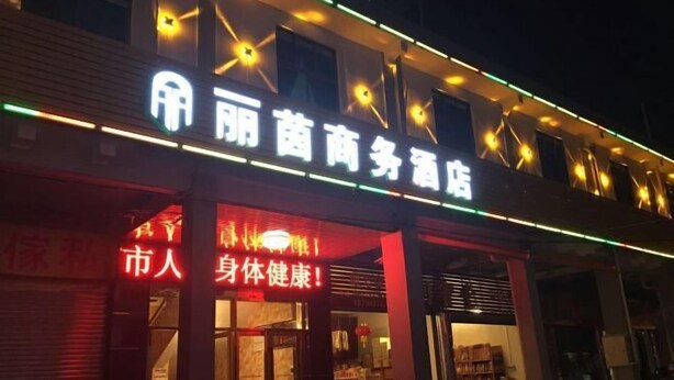 Ein Gebäude mit einem Schild, auf dem „丽菌商务酒店“ steht.