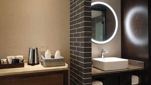 Une salle de bain équipée d’un lavabo, d’un miroir et d’un porte-serviettes.