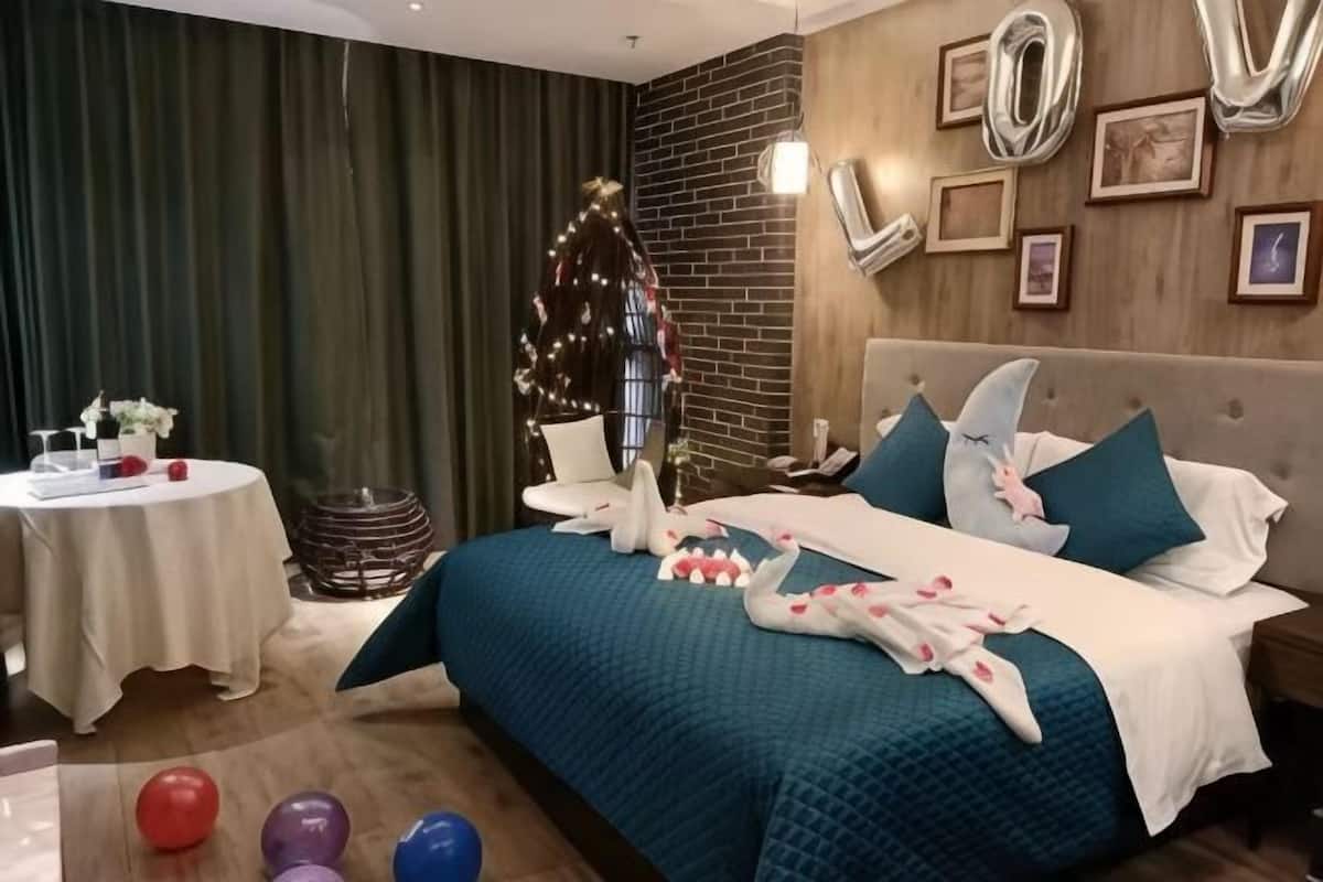 A bedroom with a bed, a round table, and a Christmas tree.