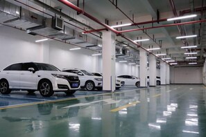 A parking garage with multiple white cars parked in rows. - Siji Garden Hotel (Ankang)