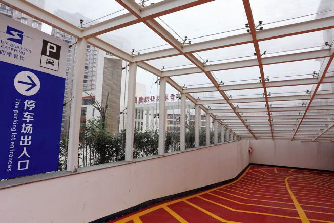 A covered parking area with directional signage and a red and yellow floor marking.