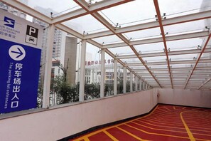 Un espace de stationnement couvert, doté d’une signalisation directionnelle et d’un marquage au sol rouge et jaune.