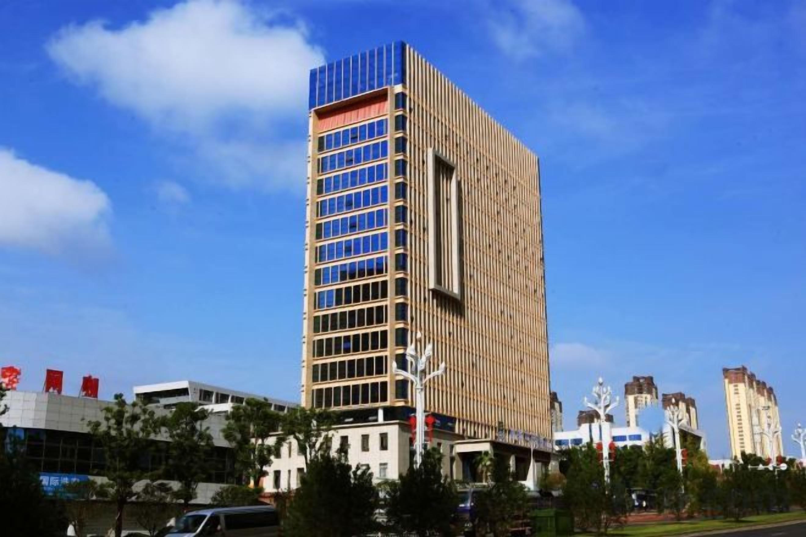 A tall, modern building with a glass facade and a flat roof.