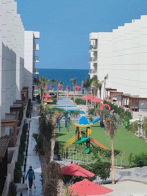 Enjoy a swim in the resort's pool surrounded by palm trees and a playground.