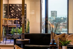 A modern interior with a sofa, a chair, a small table, and a decorative plant. - Stunning 3 bedroom luxury (York)