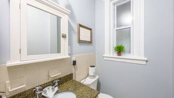 Een bad/douchecombinatie, een haardroger, handdoeken, shampoo