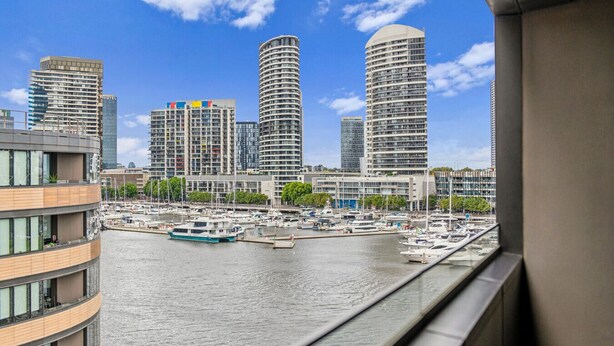 A marina with boats, a hotel, and high-rise buildings in the background. - Riverside Views Melbourne - WiFi-Netflix (Docklands)