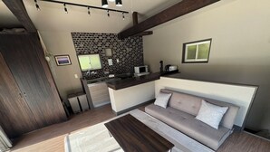 Una sala de estar moderna con un sofá, una mesa de centro y una cocina al fondo.