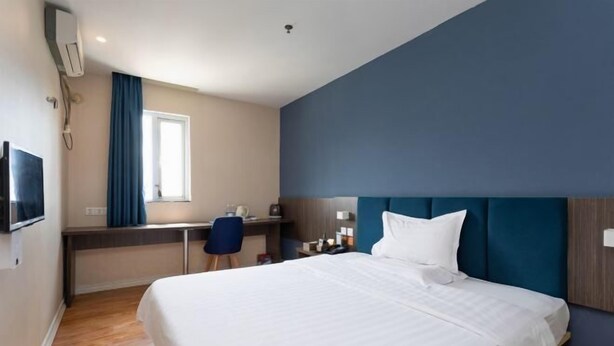 A hotel room with a bed, desk, chair, and a window. - 7Days Inn Shenzhen Shajing Metro Station public square (Shenzhen)