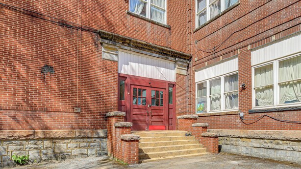 A red brick building with a red door, stone steps, and white windows. - Direct Warrior Trail Access! Ultimate ATV Getaway (Gary)