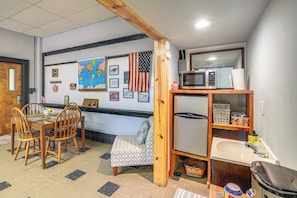 A room with a wooden dining table, chairs, a small sofa, a map on the wall, a microwave, and a sink. - Direct Warrior Trail Access! Ultimate ATV Getaway (Gary)