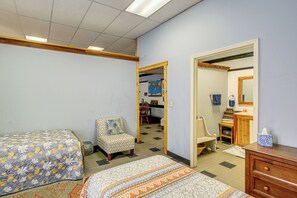 Une chambre avec deux lits, une chaise, une commode et un miroir.