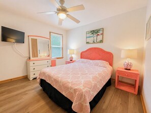 A bedroom with a bed, a dresser, a nightstand, a ceiling fan, a TV, and a painting. - 🦀 Knot Too Crabby - 5 BR home w/Private Pool & Hot Tub 🦀 (Southern Shores)