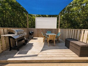 A deck with a grill, table, chairs, and a barbecue. - 🦀 Knot Too Crabby - 5 BR home w/Private Pool & Hot Tub 🦀 (Southern Shores)