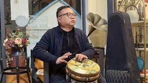 A person sitting at a table playing a drum. - Yimu Huatian Inn (Shenzhen)