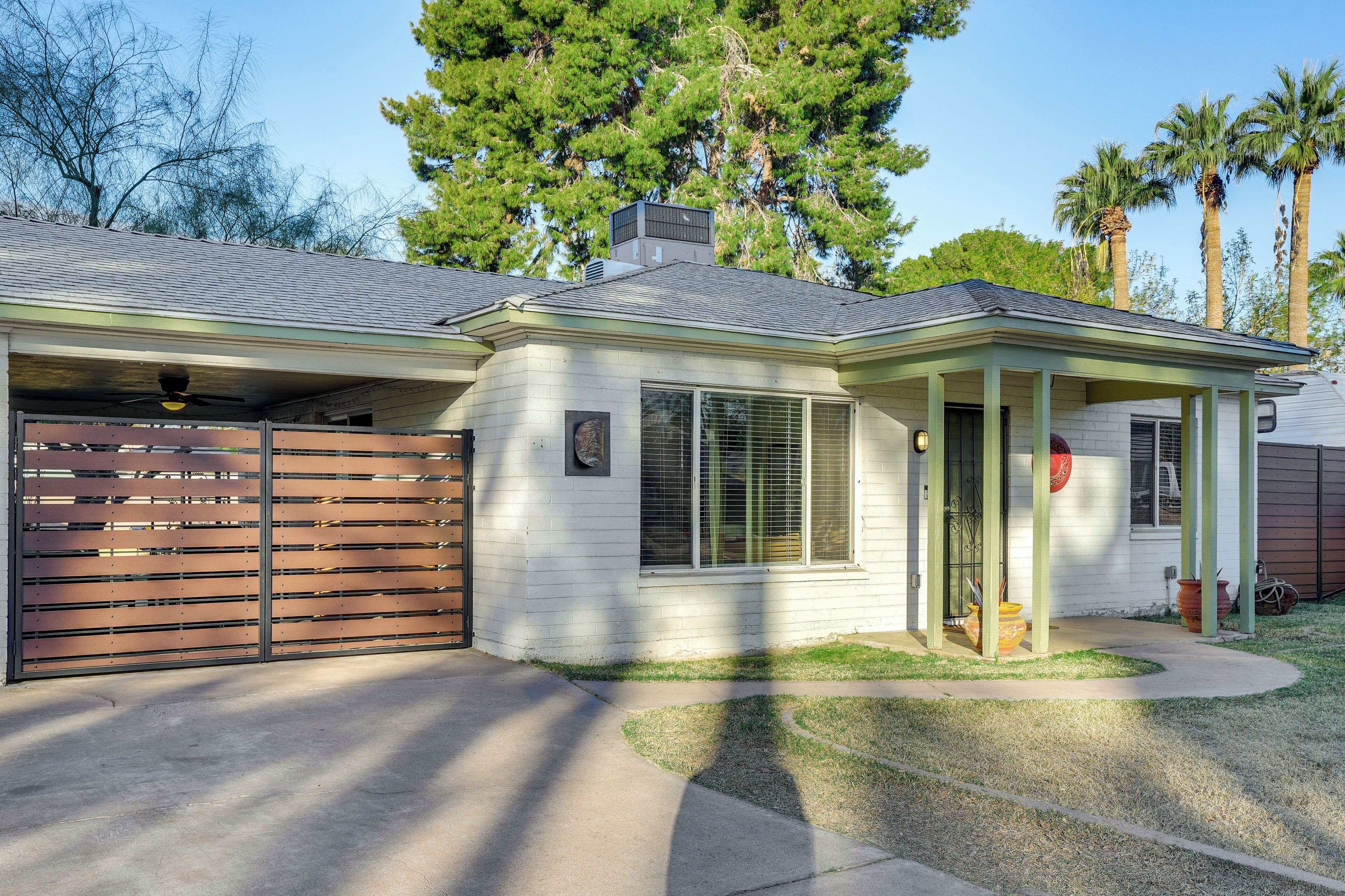 A single-story house with a covered porch, a garage, and a small front yard.