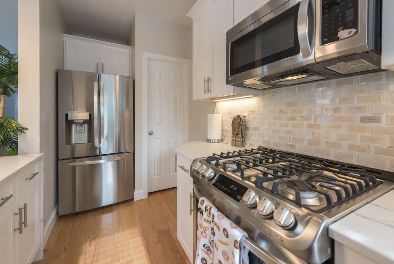 A modern kitchen with stainless steel appliances, a gas stove, and a microwave.