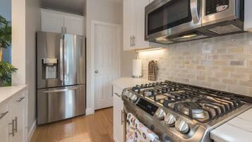 A modern kitchen with stainless steel appliances, a gas stove, and a microwave.