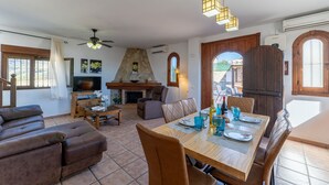 A spacious living area with a fireplace, a dining table set for four, and a comfortable seating area. - Torrox 006 (Torrox)