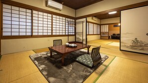 Une pièce de style japonais traditionnel, avec un sol recouvert de tatamis, une petite table en bois et une porte coulissante.