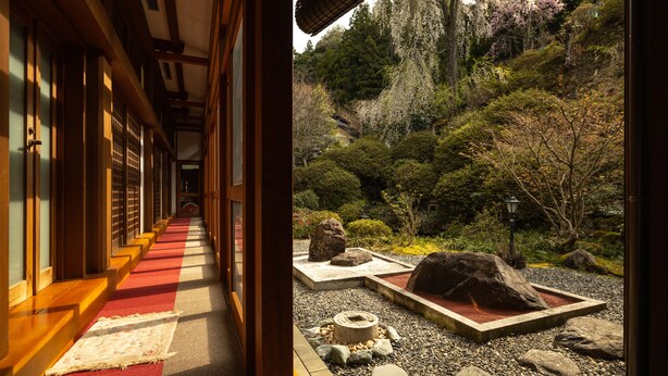 Un couloir japonais traditionnel, avec des tatamis et des portes en bois.