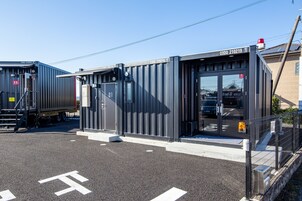A modern industrial building with a metal exterior, a loading dock, and a clear sky.