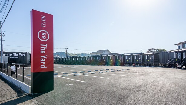A hotel sign with the name "The Yard" and a red and green pillar.