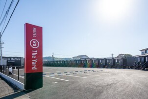 A hotel sign with the name "The Yard" and a red and green pillar.
