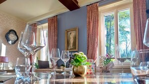 Un coin repas avec une table mise pour le dîner, comprenant des verres à vin, des assiettes et un vase décoratif.