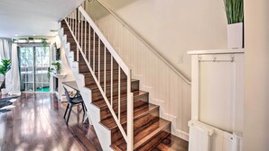Eine Treppe mit Holzstufen und weißen Geländern, die zu einer Empore führt.