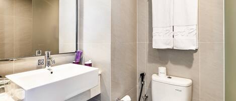 A modern bathroom with a white sink, toilet, and a towel rack.