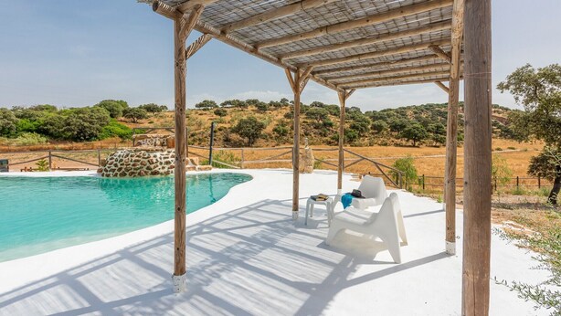 A pool area with a pergola, white lounge chairs, and a view of the landscape. - Holiday Home 'Rural El Ventorrillo' with Pool & Wi-Fi (Morón de la Frontera)