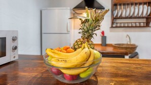A kitchen with a fruit bowl containing bananas, apples, and a pineapple. - Holiday Home 'Rural El Ventorrillo' with Pool & Wi-Fi (Morón de la Frontera)
