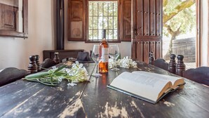 A rustic wooden table with a bottle, glasses, and an open book. - Holiday Home 'Rural El Ventorrillo' with Pool & Wi-Fi (Morón de la Frontera)