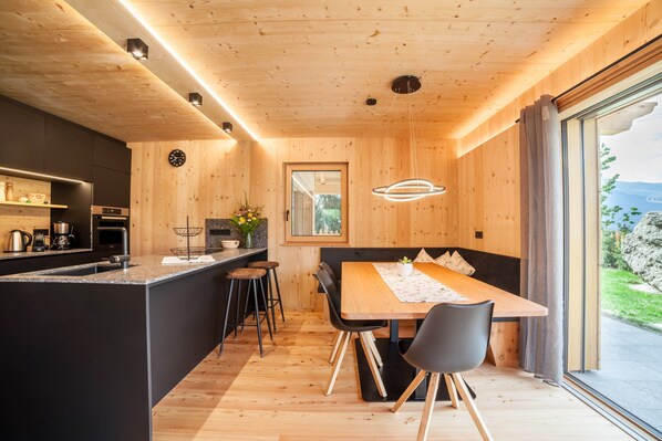 Et moderne køkken med en træø, barstole og et spiseområde med et bord og stole.