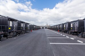 A row of identical, dark-colored hotel rooms with external stairs and a clear sky. - HOTEL R9 The Yard Yatsushiro (Yatsushiro)