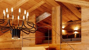 A wooden interior with a staircase, a chandelier, and a window with a view. - High Luxury Chalet "K Lodge Mountain" with Mountain View, Whirlpool and Sauna (Olang)