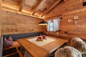 A wooden cabin interior with a wooden table, bench, and fur cushions. - High Luxury Chalet "K Lodge Mountain" with Mountain View, Whirlpool and Sauna (Olang)