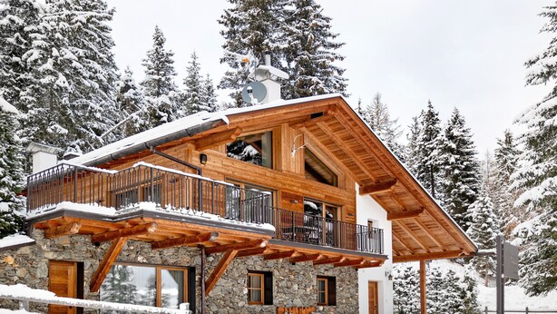 A wooden chalet with a balcony, stone walls, and a ski lift in the background. - High Luxury Chalet "K Lodge Mountain" with Mountain View, Whirlpool and Sauna (Olang)