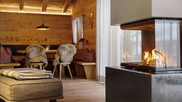 Una habitación acogedora con chimenea, muebles de madera y un banco.