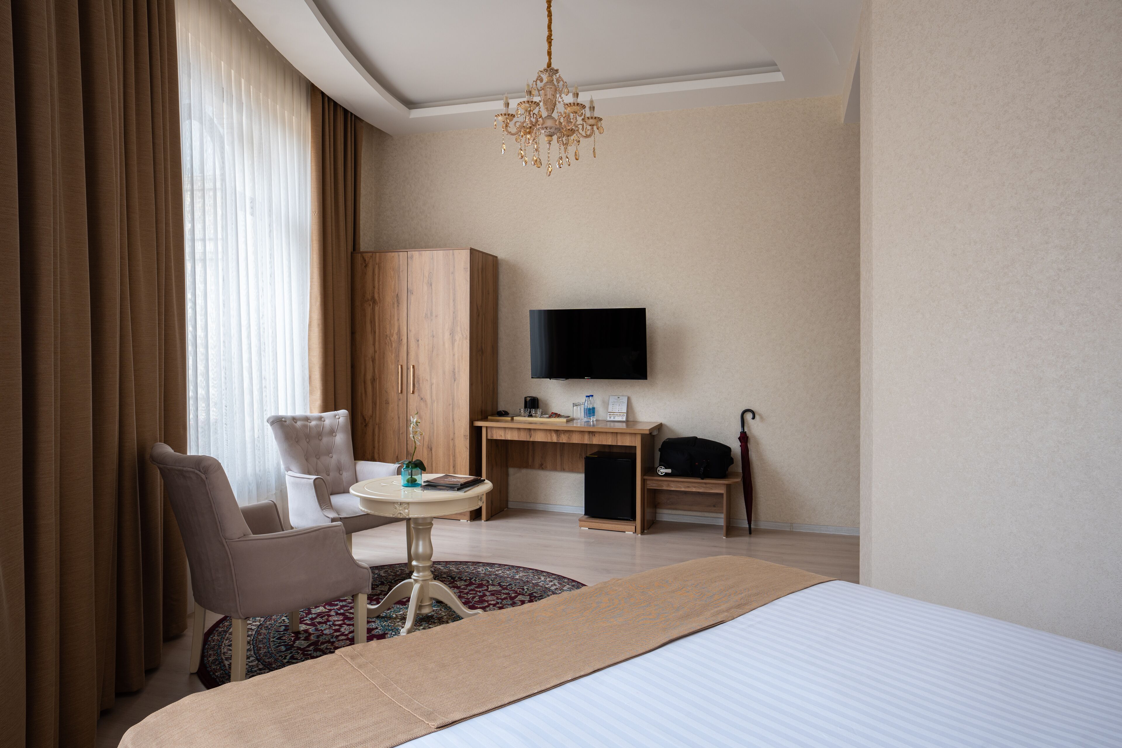 Une chambre d’hôtel équipée d’un lit, d’un bureau, d’une chaise, d’une télévision et d’une armoire.
