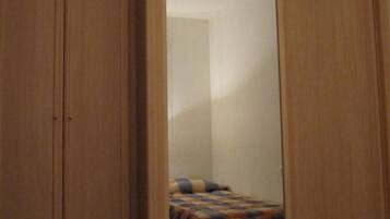 Ein Schlafzimmer mit einem Bett, einem Kleiderschrank und einem Spiegel.