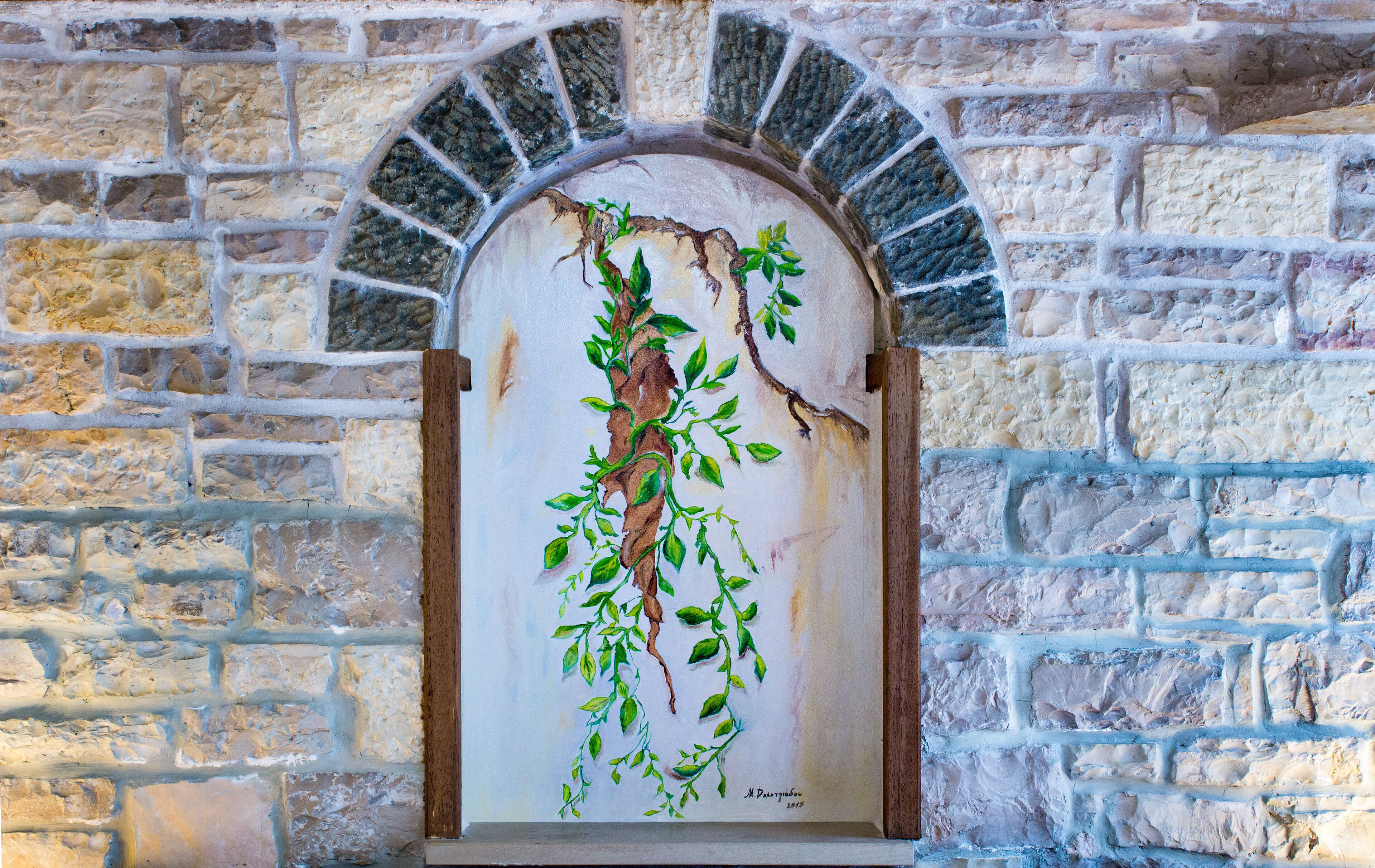 Una pared de piedra con una puerta de madera y una enredadera pintada.