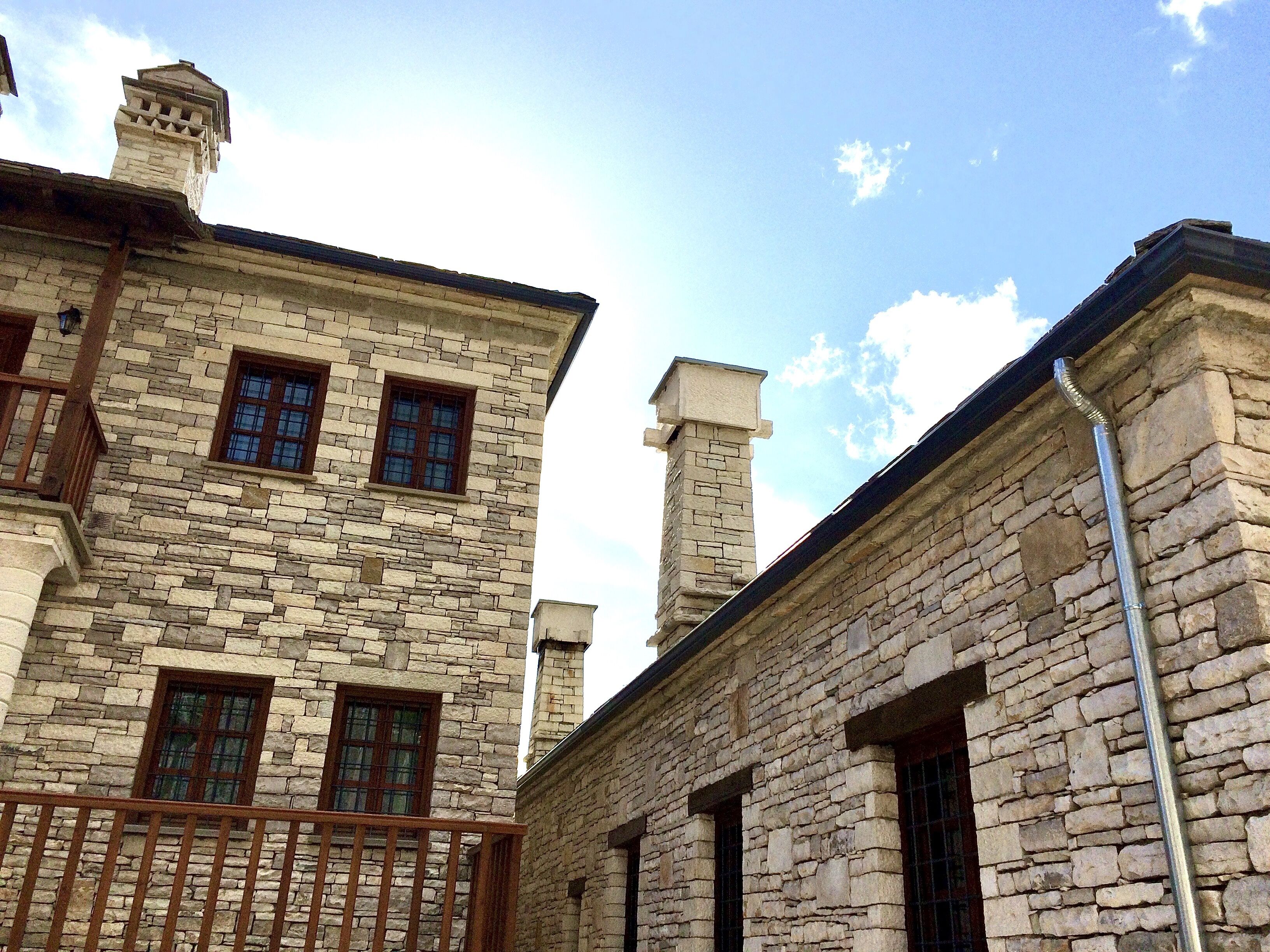 A stone building with multiple windows and a balcony.