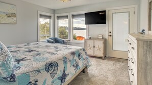 A bedroom with a bed, a TV, a window with a view, and a door. - Waterfront PNW Escape w/ Deck & Beach Access! (Port Hadlock-Irondale)