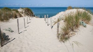 A sandy beach path leading to the ocean with wooden posts and sparse vegetation. - Beautiful 10p villa with private pool, jacuzzi & tennis court (Vers-Pont-du-Gard)
