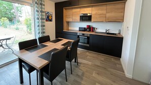 A modern kitchen with black cabinets, a wooden countertop, and a built-in microwave.