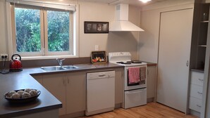 A kitchen with a window, a sink, a stove, a dishwasher, and a toaster.