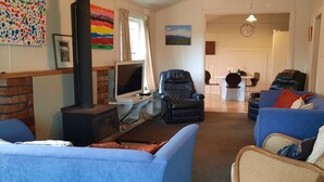 A living room with a fireplace, a television, and two sofas.