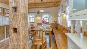 Un coin repas en bois avec une grande table, des chaises et un poteau en bois.